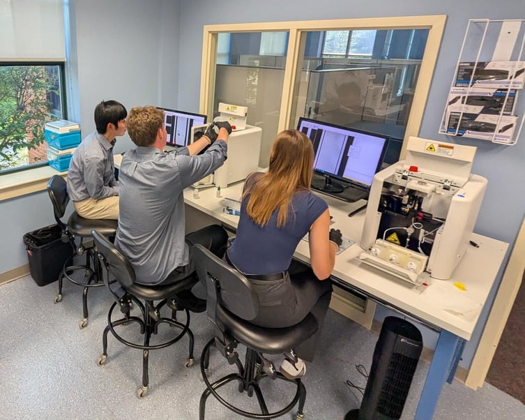 3 people seated at a lab bench working with FlowCams
