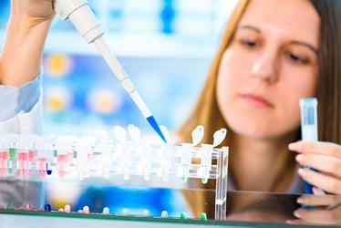 Scientist pipetting sample into rack of vials