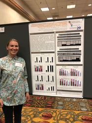 Woman standing in front of scientific poster at conference