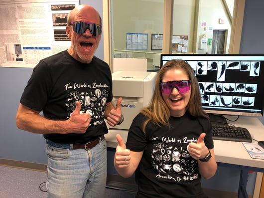 Harry Nelson and Savannah judge with FlowCam wearing sunglasses and zooplankton tshirts, giving thumbs up