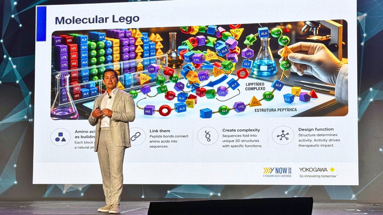 A man on a stage with a presentation screen behind him titled "Molecular Lego"