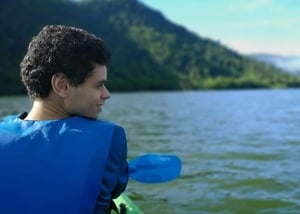 Young man in kayak with mountains in background
