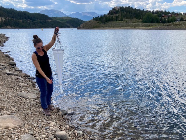 Applications scientist monitors water quality by sampling with plankton net in Colorado