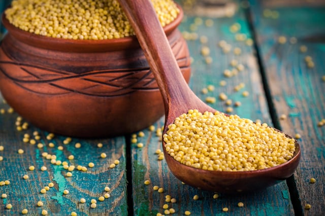 Spoonful of millet grain on tabletop