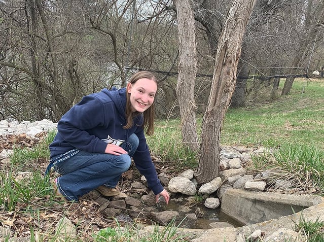 Jennifer Davis collecting a water sample from a stormwater drain