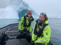 Two women in boat along the West Antarctic Peninsula in background