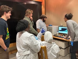 Scientists gathered around FlowCam monitor looking at data