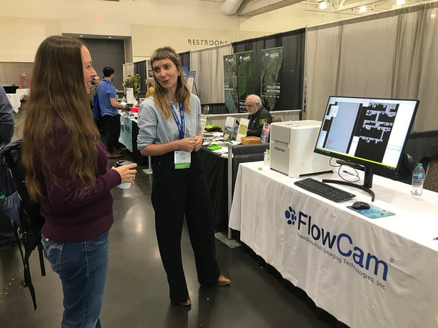 Woman demonstrating FlowCam at trade show booth