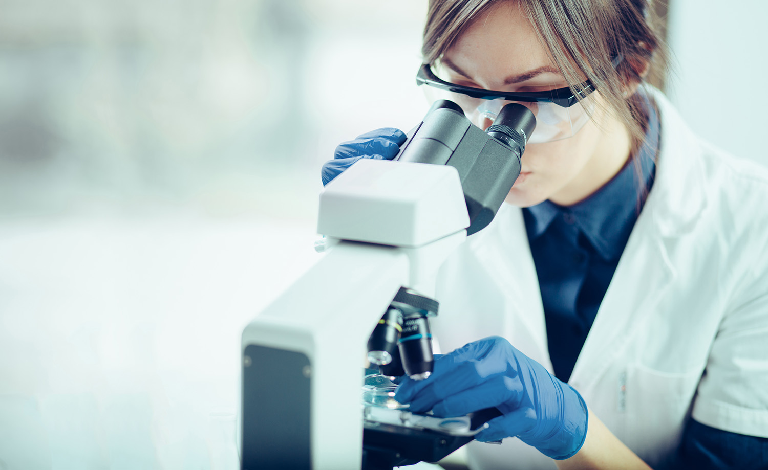 Stock photo of scientist using microscope