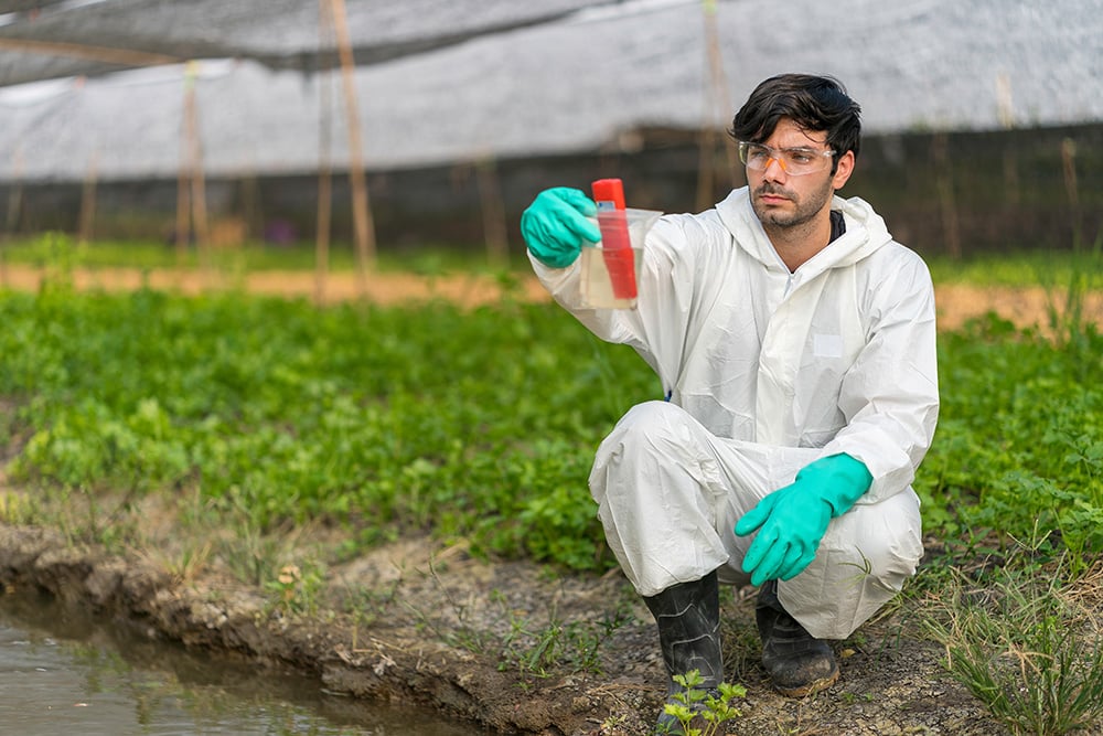 Man testing water sample in agriculture setting